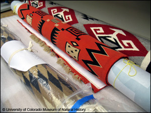 Photograph of Navajo rugs rolled on padding for storage