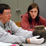 Image of anthropology and MFS students in class examining a ceramic pot