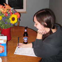 Image of two female Museum Club members at potluck, one filling out a survey form