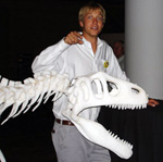 Image of male MFS student and life-size dinosaur skeleton puppet