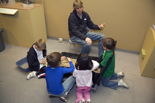 Photo of John Hankla helping kids with a paleontology activity at a Museum family day